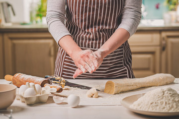 Woman bake pies. Confectioner makes desserts. Making buns. Dough on the table. Knead the dough.