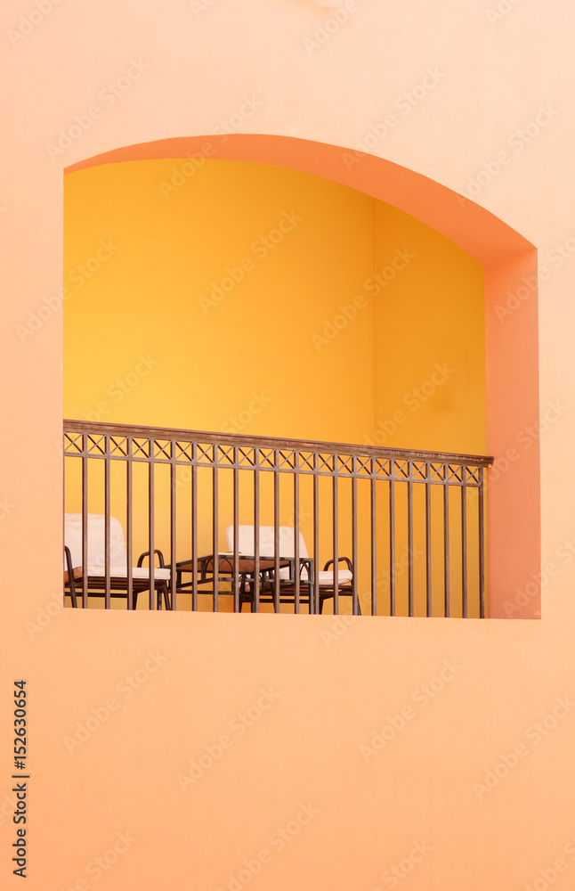 Minimalist picture of yellow building wall and terrace with chairs and table for rest in the center. - obrazy, fototapety, plakaty 