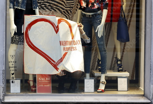 An Employee Holds A Banner In A Shop Window To Advertise For The