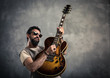© ZoneCreative - adult caucasian guitarist portrait playing electric guitar on grunge background. Music singer modern concept
