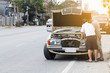 © JC_STOCKER - Man repairing broken car on road