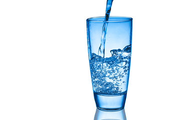 Pouring water into transparent glass isolated on white.