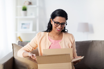 happy young indian woman with parcel box at home