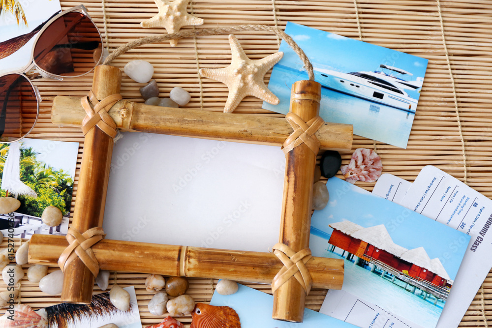 Travel concept. Composition with photo frame on bamboo mat background