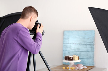 Wall Mural - Young man photographing food in professional photo studio