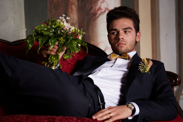 young groom waiting his bride on sofa