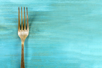 Vintage fork on vibrant turquoise with copyspace