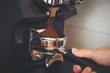 Coffee grinder grinds freshly coffee beans in a portafilter