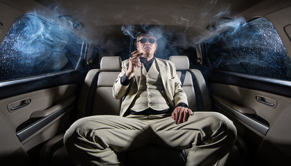 A rich man in a white suit and a cigar in the car, a limousine