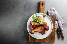 Pork Ribs On White Plate On Slate Background. Copy Space