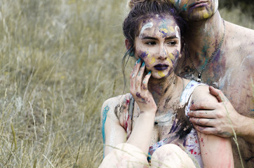 modern couple posing in nature with dirty colors over skin