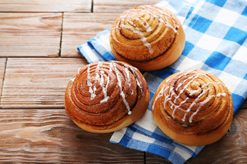 Wall Mural - Cinnamon buns with napkin on wooden table