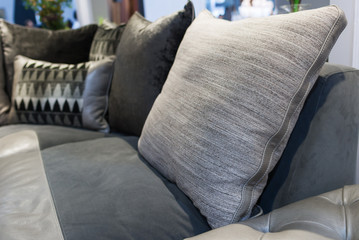 Modern fabric gray pillow on luxury leather sofa interior