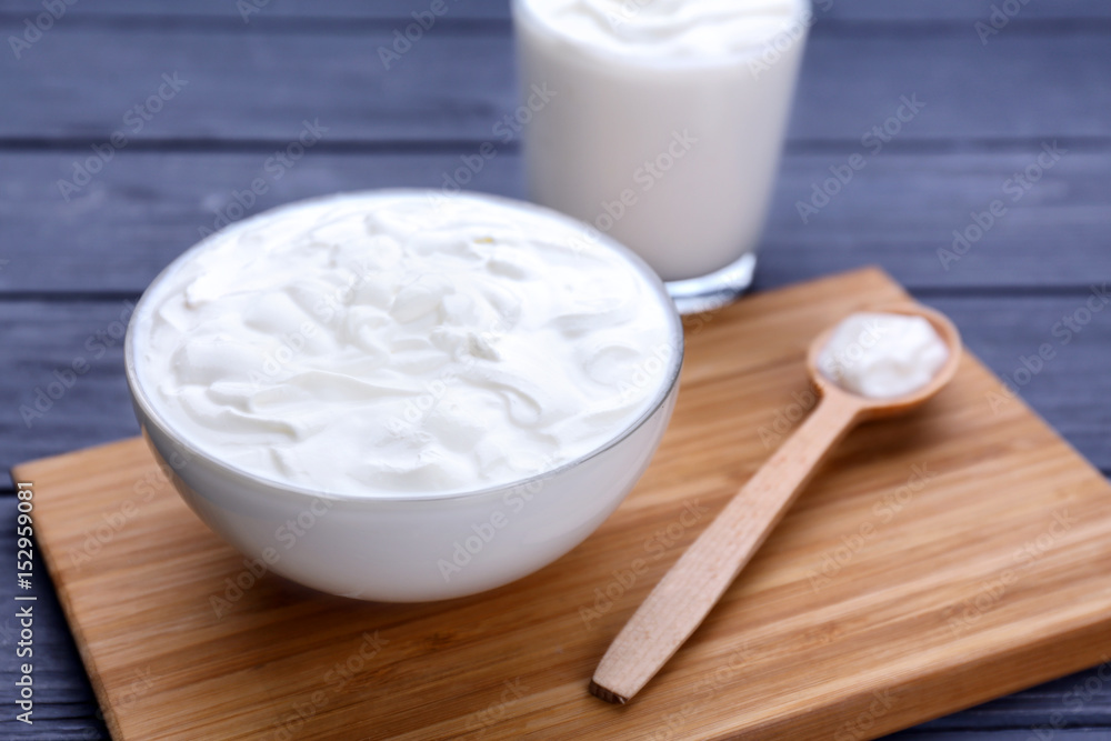 Bowl with yogurt on wooden board