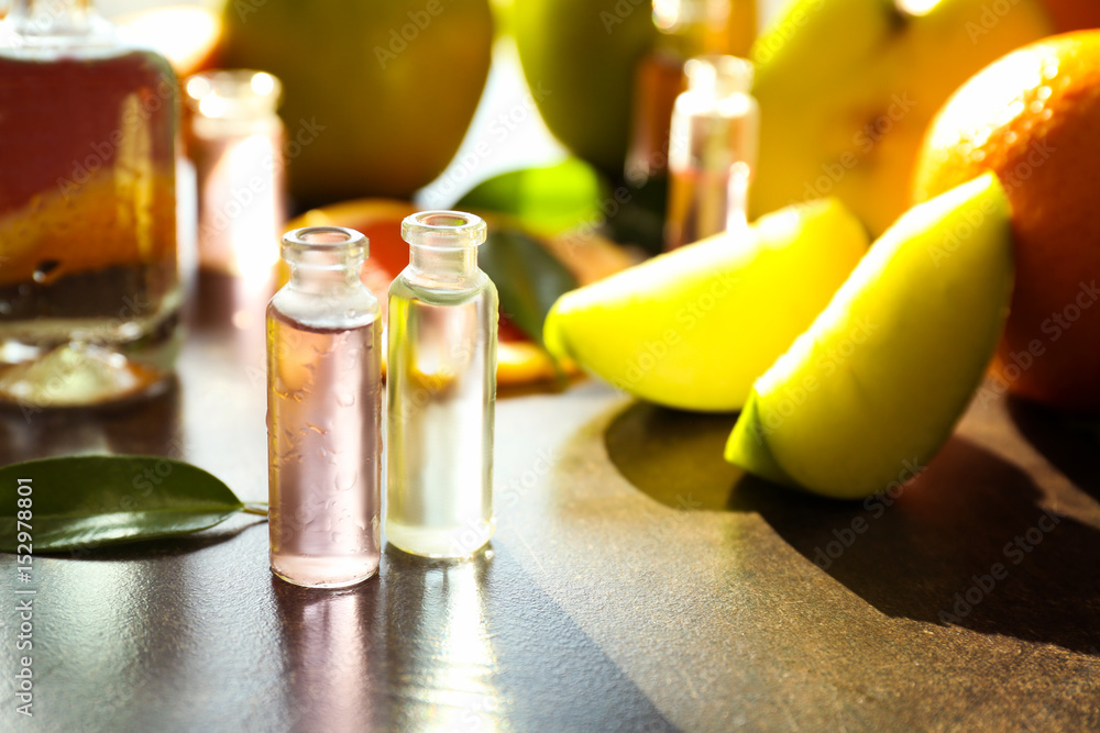 Perfume bottles and fresh fruits on table