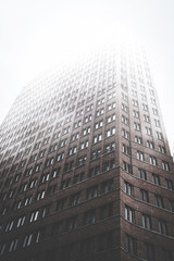 high rise  building facade in misty fog