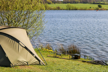 fishing tent with a fishing rod on the shore of lake