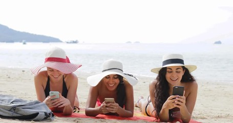 Wall Mural - Three Girls Using Cell Smart Phone Lying On Beach Talking, Chatting Online Young Woman Communication Tourists On Summer Holiday Slow Motion 60