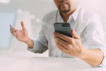 Big data analytics with business intelligence (BI) concept. businessman using mobile phone and laptop computer on white desk