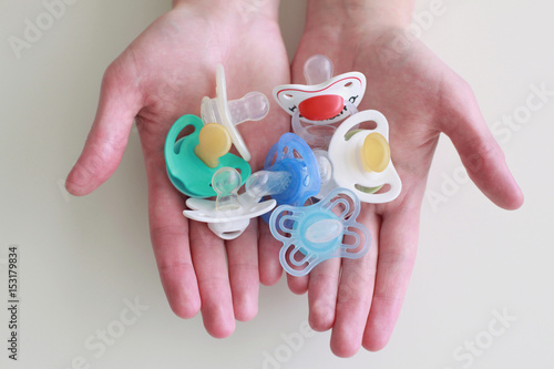 Fotografija  Baby pacifiers in hands