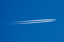 Large Passenger Liner And Trail From An Airplane In A Blue Sky.