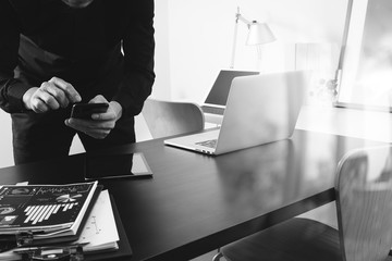 Poster - businessman or Designer using smart phone with latop and digital tablet computer and document on desk in modern office,black and white