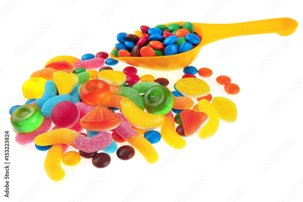 Tasty fruit candies and scoop on white background