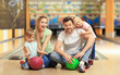 © Africa Studio - Happy family sitting on floor in bowling club