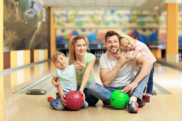 Canvas Print - Happy family sitting on floor in bowling club