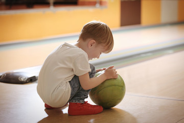 Wall Mural - Cute child with ball in bowling club