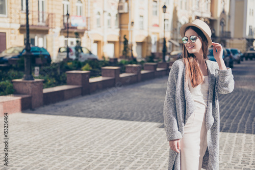 Cuadros en Lienzo Happy young girl on vacation in a stylish hat and sunglasses, wearing pure light