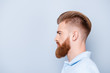 © deagreez - Advertising barbershop concept. Profile side portrait of confident handsome red bearded young man. He has a perfect stunning hairstyle, modern haircut