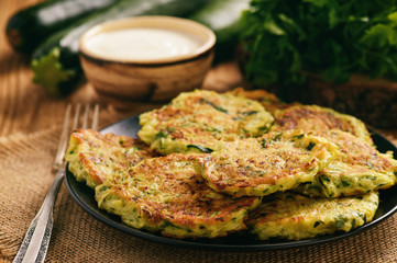 Wall Mural - Vegetarian food - zucchini fritters on wooden background.