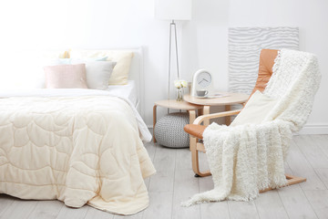 Poster - Chair near comfortable bed with soft beige coverlet and pillows in light modern room