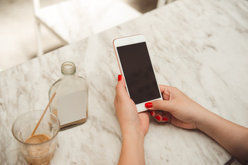 Closeup of woman holding and showing screen of her smartphone