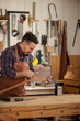 © dzhafarov_eduard - Carpenter Finishing Wooden Horse Toy/Middle aged handsome carpenter  making final touches to the Horse Toy