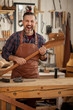 © dzhafarov_eduard - Happy Crazy Carpenter/Middle aged handsome carpenter  finished making horse toy and smiles to the camera