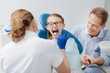 © zinkevych - Adorable positive girl visiting dentist with her dad