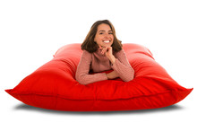 Attractive Young Woman Lying On Red Square Shaped Beanbag Sofa Isolated On White Background