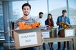 © WavebreakMediaMicro - Smiling man holding a donation box in office