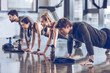 © LIGHTFIELD STUDIOS - group of athletic young people in sportswear doing push ups or plank at the gym, group fitness concept