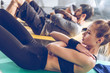 © LIGHTFIELD STUDIOS - Sporty young people doing abs on yoga mats while exercising at the gym