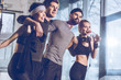 © LIGHTFIELD STUDIOS - side view of group of sportive people near trx equipment in gym
