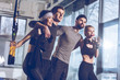 © LIGHTFIELD STUDIOS - side view of group of sportive people near trx equipment in gym
