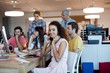 © WavebreakMediaMicro - Woman with headphones working with her team in office