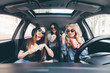 © F8  \ Suport Ukraine - three girls driving in a car and having fun eating fast food in travel road trip