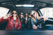 © F8  \ Suport Ukraine - Group of friends having fun whet drive the car. Singing and laughing on the road