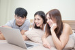 © Jestercine - Asian man and woman using computer on bed, Young people portrait in bedroom, 20-30 year old.