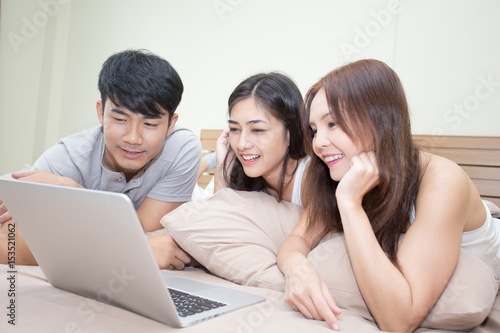 Asian Man And Woman Using Computer On Bed Young People