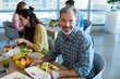 © WavebreakMediaMicro - Smiling man having meal with his colleagues